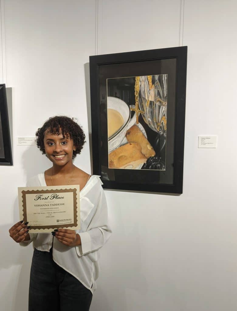 First place winner posing with her pastel piece and certificate in ARTfactory gallery